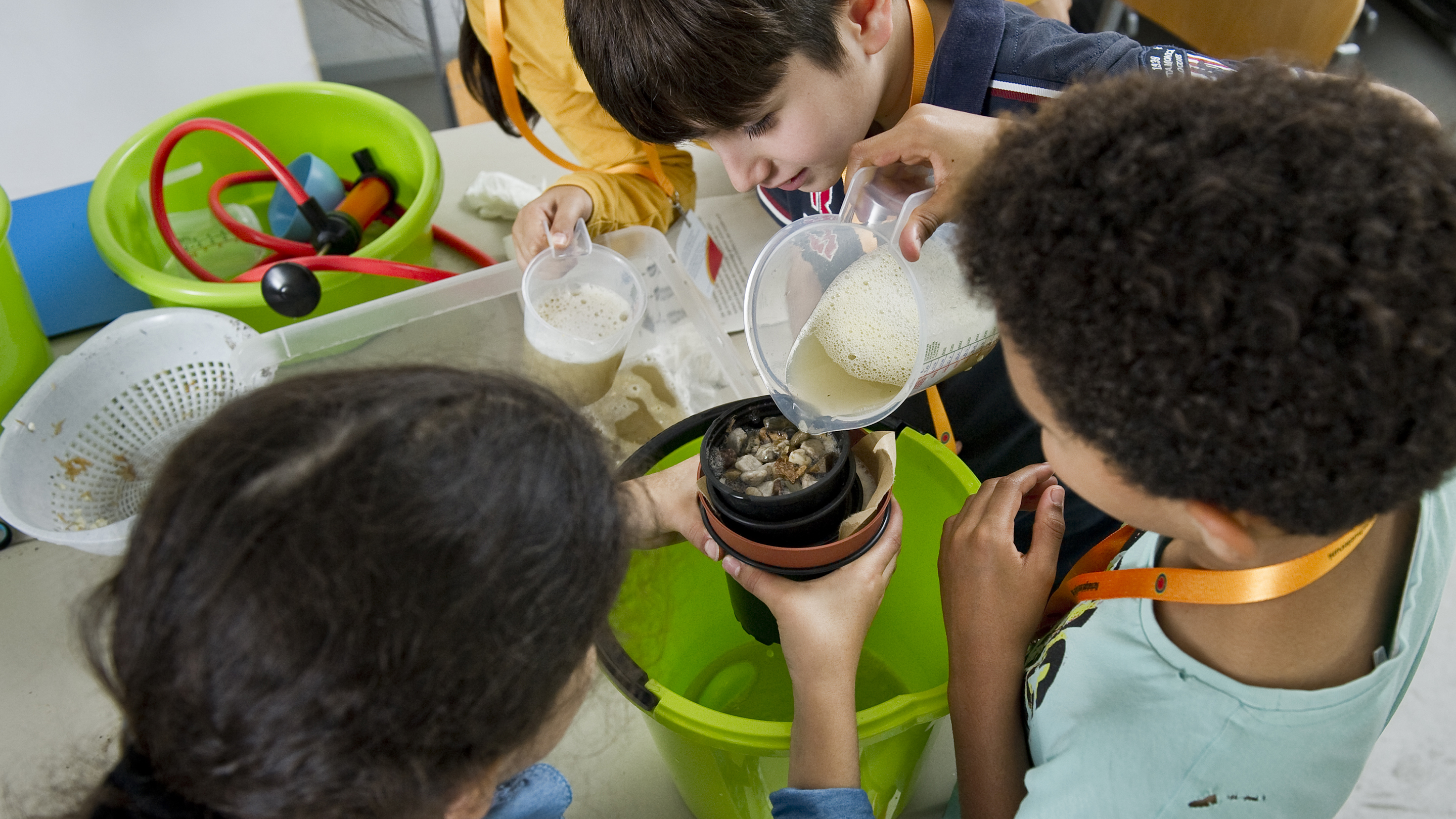 Kinder experimentieren mit Filtern, um Schmutzwasser zu säubern