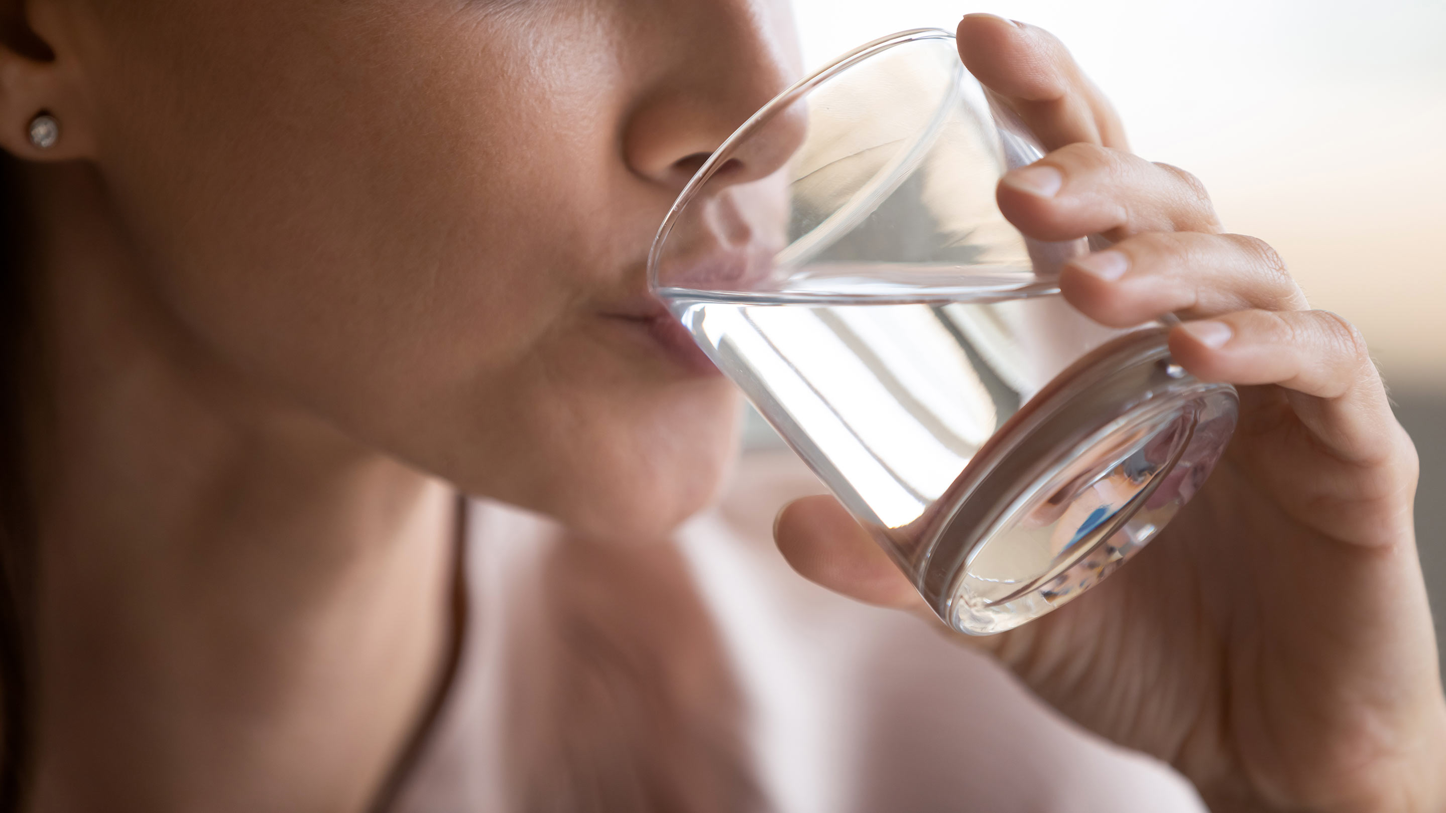 Frau trinkt aus einem Glas mit Wasser