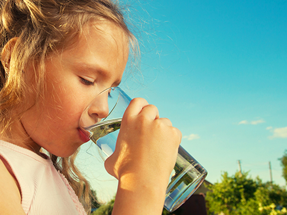 Mädchen trinkt ein Glas Leitungswasser